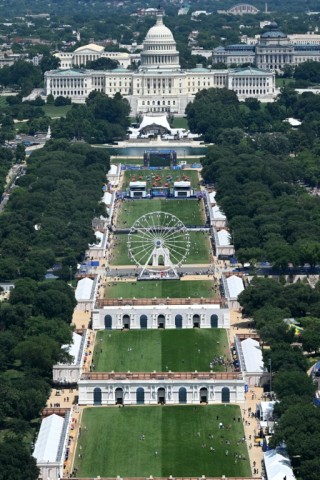 The Ferris wheel is seen with the US Capitol in the distance during the “Great American State Fair" as seen from the Washington Monument