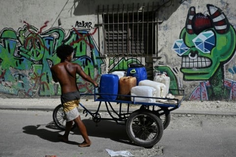 A man transports water containers during a nationwide power outage in Havana on July 6, the third since the start of the year