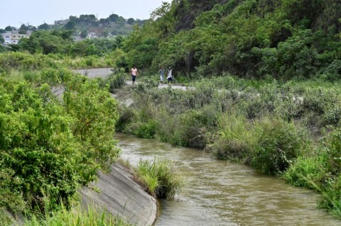 Locals walk along the Canal de la Muerte (Death Canal), in the Ecuadoran city of Guayaquil, where hundreds of bodies have been found in the midst of the country's drug wars