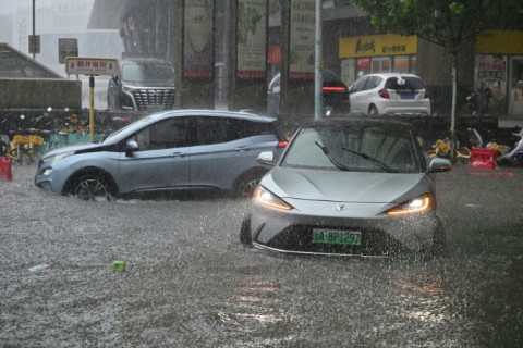 Cars driven along a flooded street in Beijing on July 7