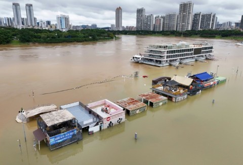 Flooded shops along a submerged riverside walk are seen by the overflowing Yongjiang river in Nanning
