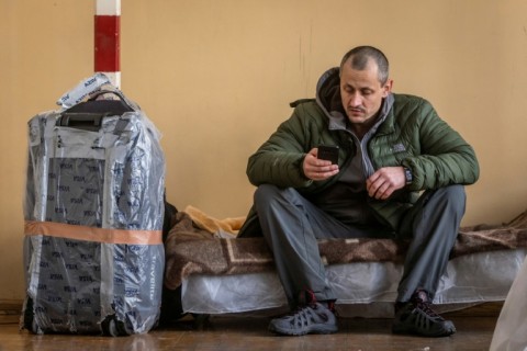 Un homme est assis dans un centre d'accueil temporaire pour réfugiés ukrainiens installé dans une école primaire de Przemysl, dans l'est de la Pologne, le 26 février 2022, au lendemain de l'invasion russe de l'Ukraine.
