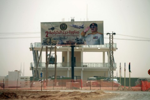 A billboard showing an image of Libyan military strongman Khalifa Haftar is erected on top of a military building