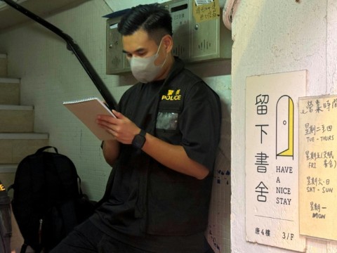A policeman stands at the entrance to the 'Have A Nice Stay' independent bookstore in Hong Kong
