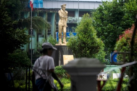 A woman walks past a statue of Myanmar’s independence General Aung San at Thu Mingalar Park
