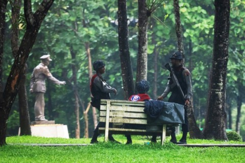 Policemen stand guard next to a statue of General Aung San at the Bogyoke Aung San Park in Yangon
