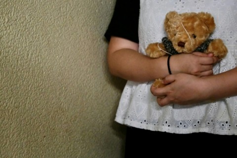 Bobo a woman who suffered persistent child sexual abuse for several years, holds a teddy bear