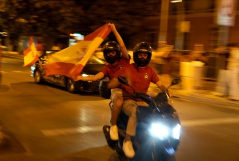 Spain supporters on a motorcycle wave the flag celebrating victory after the 2026 World Cup final