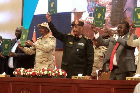 Sudan army chief Abdel Fattah al-Burhan (C R) and RSF commander Mohamed Hamdan Daglo (C L) appear on stage together in 2022, before their alliance ruptured