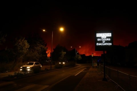 A sign near Le Porge reading 'Fire. Evacuation of the economic activity zone underway'