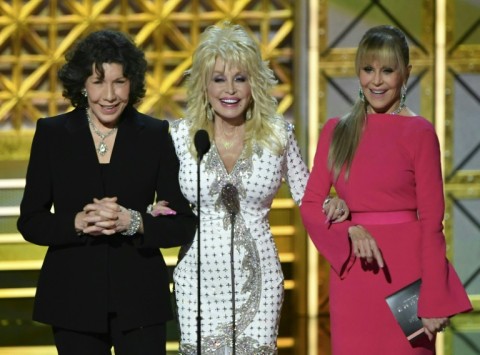At the height of her fame, Dolly Parton (C) starred in Hollywood blockbusters such as '9 to 5' with Lily Tomlin (L) and Jane Fonda (R) -- the trio presented at the 2017 Emmys