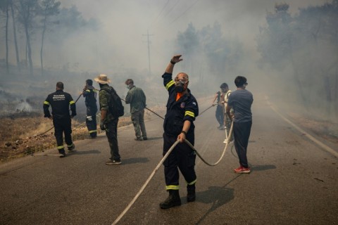 Volunteers and Greek firefighters work to extinguish a wildfire some 70 kilometres (45 miles) northwest of Athens