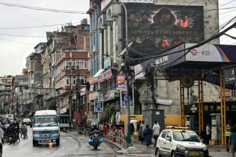 A digital billboard (top, R) displays the condolences after the death of mountaineer Nirmal Purja and his companions by an avalanche in Pakistan