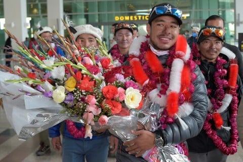 Nepal's climber Nirmal Purja (2R) walks upon his arrival along with his team at the airport after becoming the firsts to summit Pakistan's K2 mountain in winter, in Islamabad on January 21, 2021