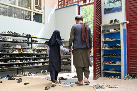 An Afghan father collects his daughter from primary school in Kabul