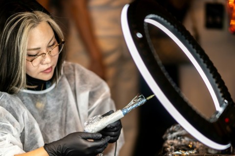 A scalp tattoo artist conducting a demonstration during a contest in Naha, Okinawa Prefecture