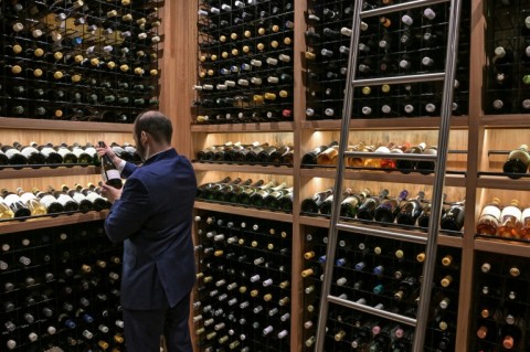 The evening begins with cocktails beneath a towering jabuticaba tree, native to Brazil, standing alongside a glass-enclosed wine cellar housing 5,000 bottles