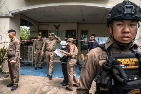 Police gather outside the house where a teenager is suspected of killing his grandparents before carrying out a school shooting north of Thailand's capital Bangkok.