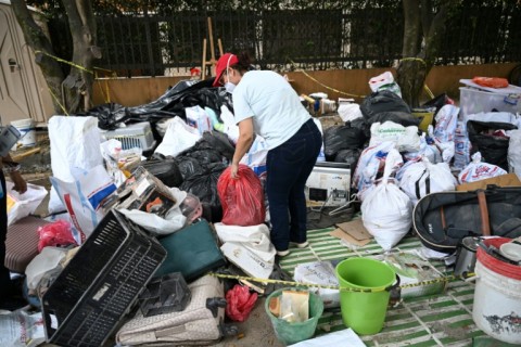 A woman looks through her belongings that have been recovered by volunteers after a magnitude 7.4 earthquake flattened her residential complex in Cali, Colombia