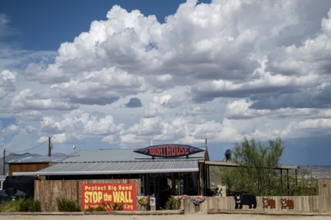 A protest sign reading 'stop the wall' is seen on a state road that leads into Big Bend National Park