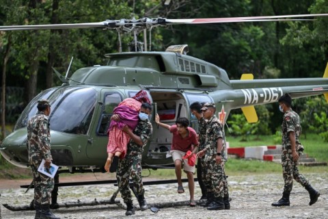 An Army personnel carries out an elderly woman from a helicopter during a rescue operation in the aftermath of Nepal-Tibet flash floods