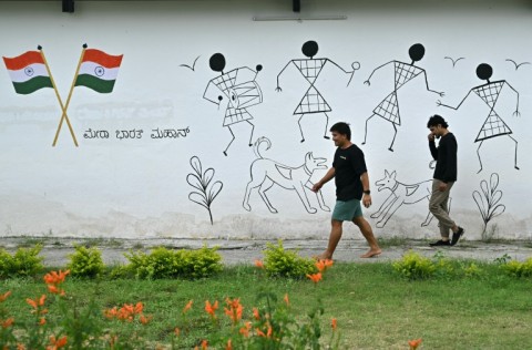 Employees walk past a wall mural inside the Dognosis facility in Kempohalli village on the outskirts of Bengaluru