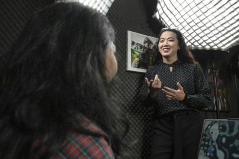 Transgender woman and activist Dania Joedo chats with a colleague at her office in Jakarta