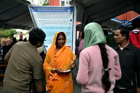 Family members register their information with Nepali police personnel to give blood samples for DNA testing to help identify their missing relatives