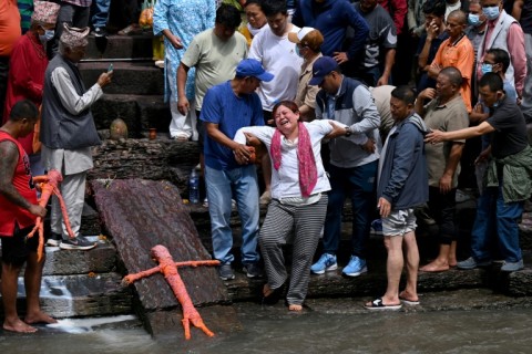 Relatives mourn flood victims still reported missing as they cremate Kush grass effigies in accordance with Nepali Hindu rites at Pashupatinath temple