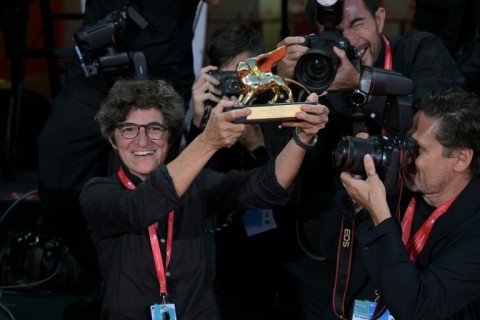 The photograph snapped by Clooney of bemused Fabi holding up the actor's Golden Lion