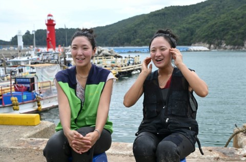 South Korean haenyeo Woo Jung-min (L) and Jin So-hee (R) speaking during an interview with AFP in the South Korean coastal town of Geoje