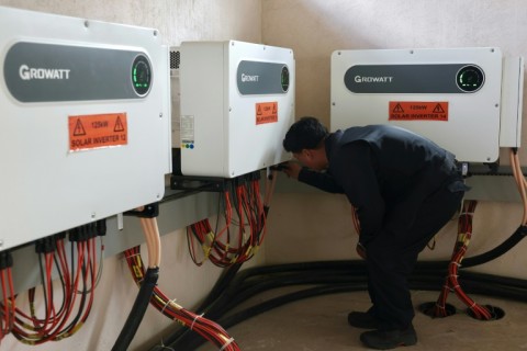 Senior engineer Rinzin Galley checks solar inverters in a control room at the Norion Renewable Energy company compound in Bhutan's capital city of Thimphu