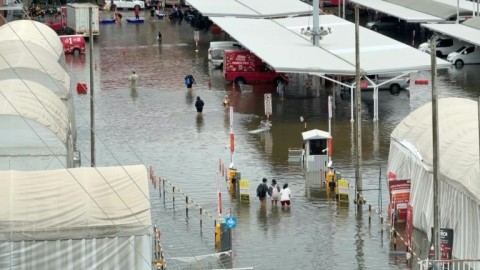 Pedestrians wade through flooded Bangkok roads after days of rain