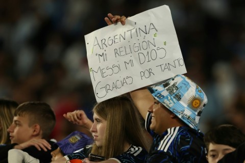 A fan holds up a sign which reads: "Argentina. My religion. Messi my God. Thanks for everything."