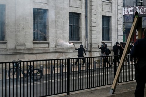 A protester holds a firework stick during protests in the soutwestern town of Bordeaux