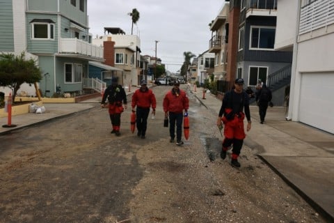 Members of the fire department inspect storm damage on the boardwalk and homes created by Tropical Storm Rachel in Long Beach, California