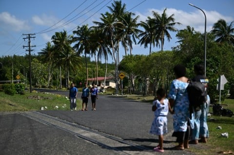 This photo taken on October 9, 2026 shows residents walking along a road in Rukurukulevu village. Government minister Ro Filipe Tuisawau blamed Fiji's rising energy prices on overreliance on fossil fuels and El Nino.