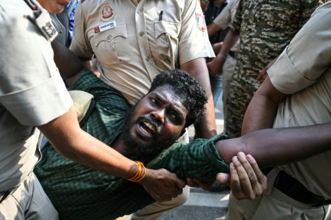 Security forces detain a student activist during a protest in New Delhi