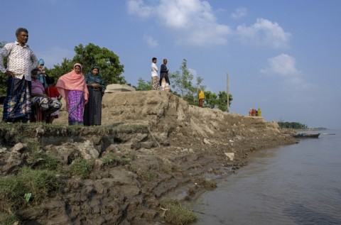 Villagers stand along the eroded Padma river embankment at Namo Jagannathpur village