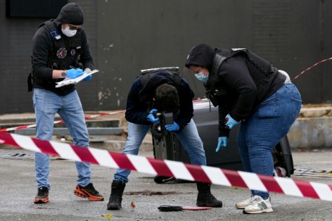 Forensics teams collect evidence at a petrol station in Trappes, outside Paris, where a man opened fire on residents