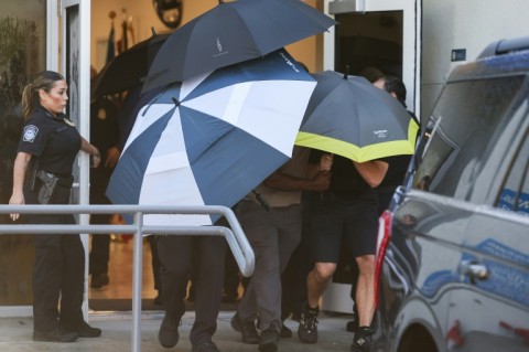 US agents with umbrellas shield people leaving Opa-Locka Executive Airport in Florida shortly after Brazil's Flavio Bolsonaro and his family arrived on a private jet