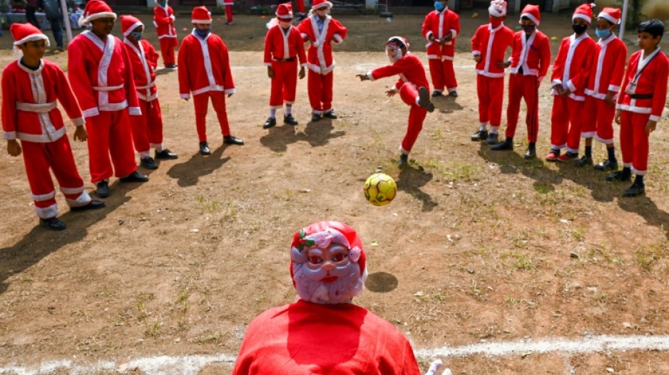 Children dressed as Santa Claus play with a soccer ball as they celebrate at their school ahead of Christmas in Chennai