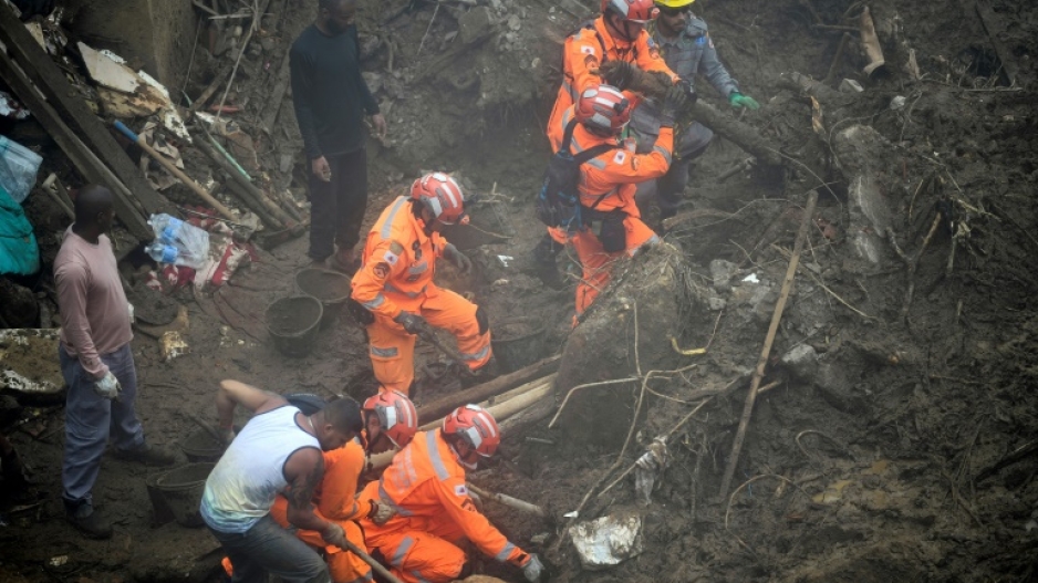 In a dense fog, rescue workers sort through the rubble and muck on February 19, 2022 as the search following landslides and flooding in Petropolis, Brazil entered its fifth day 