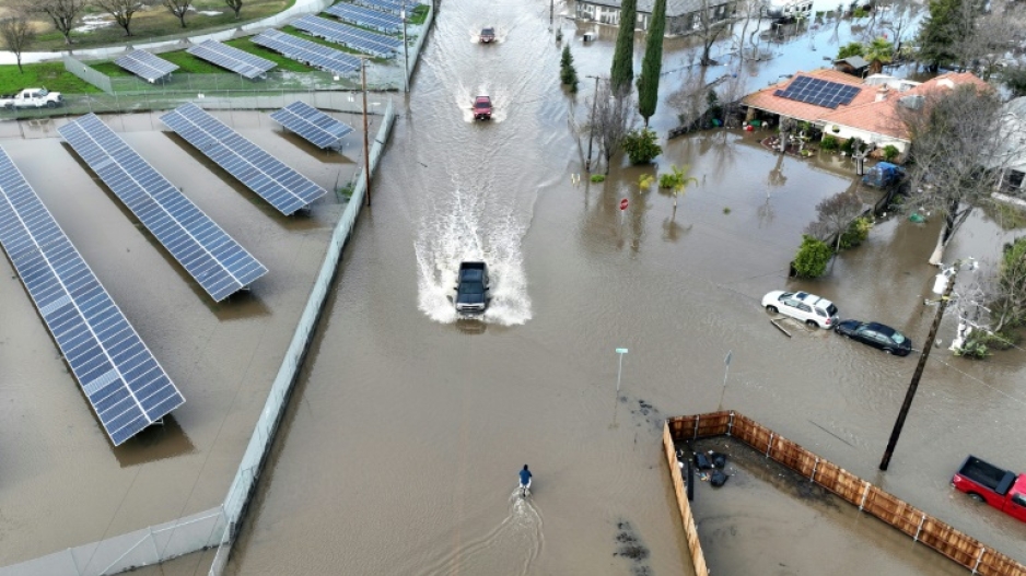 Cars driving through a flooded roadway in Planada, California, as an "atmospheric river" continues on January 10, 2023