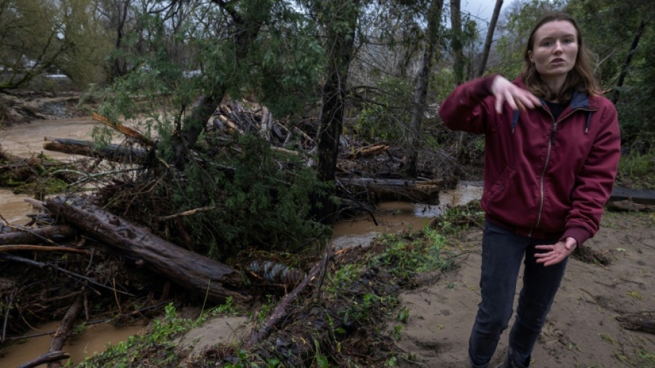 Amberlee Galvin stands next to evidence of the flooding that has ravaged the town of Felton 