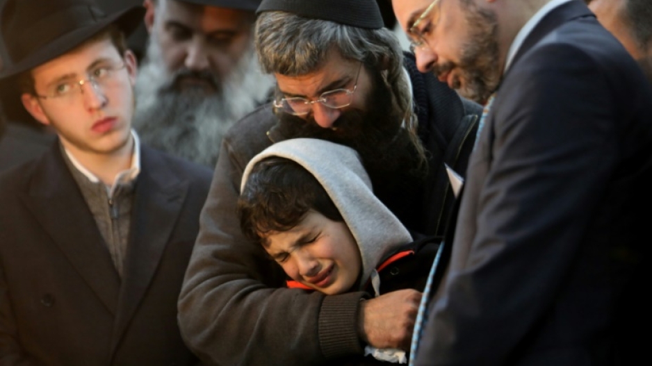 Aharon Natan, the father of 14-year-old Asher Natan, a victim of a shooting attack in east Jerusalem on January 27, 2023, mourns with her other son during his funeral at a cemetery in Jerusalem, on January 29, 2023
