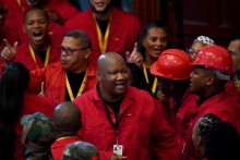 Members of the Economic Freedom Fighters (EFF), wearing their signature red overalls, sing as they arrive at the Cape Town City Hall. AFP/Rodger Bosch