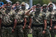 Members of the South African Police Service (SAPS) Special Task Force salute during the Integrated Law Enforcement parade near the Nasrec Expo Centre in Johannesburg, on November 19, 2025.