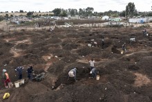 This aerial view shows artisanal miners digging holes as they look for gold in a patch of land outside Springs, Ekurhuleni, on February 15, 2026.