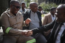 South Africa's Gauteng Province Premier Panyaza Lesufi (L) shakes hands with Evangelist Sipho Trevor Dlamini (R) before protesters handed him a memorandum during a protest march against undocumented migrants organised by “March and March” in Johannesburg on April 29, 2026.